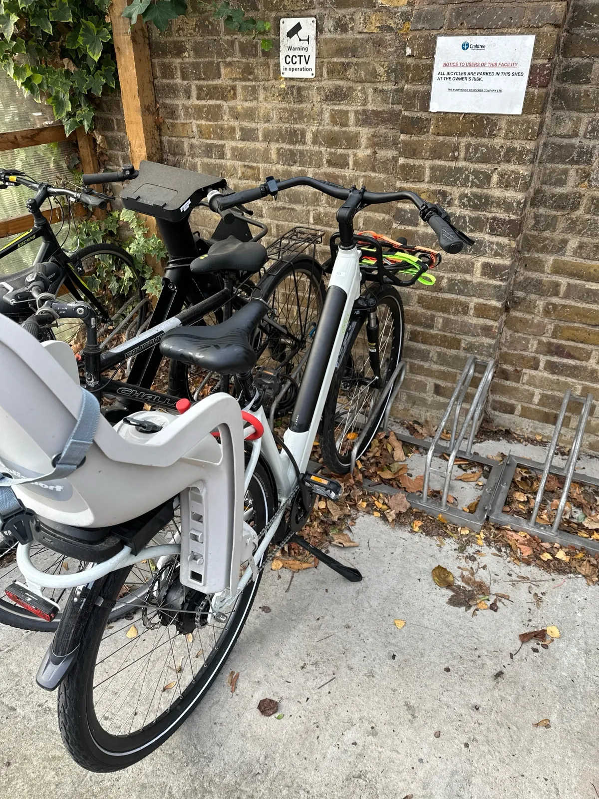 Family e-bike parked beside a secure bike store on a London residential street